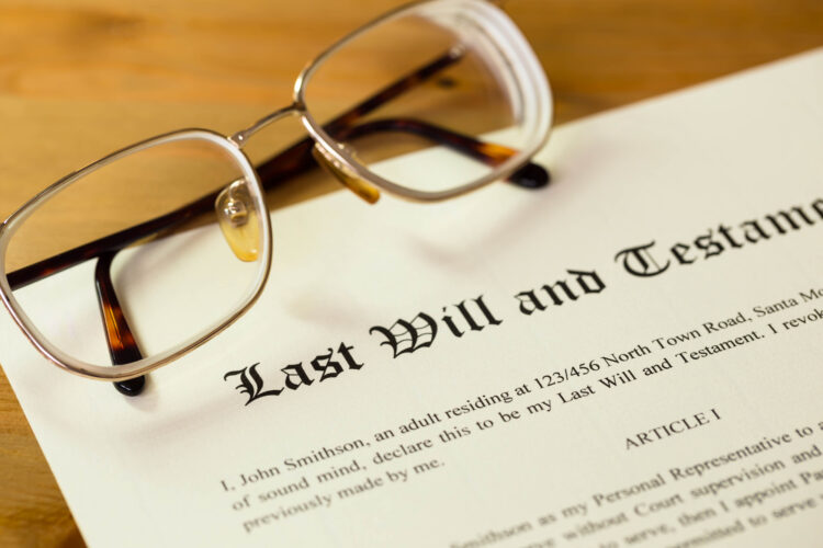 Common Mistakes To Avoid With Probate - Last will and testament on cream color paper with glasses