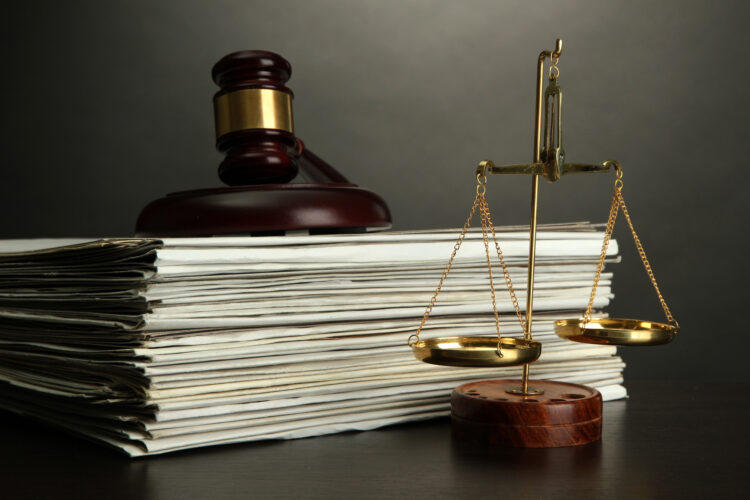 personal injury lawyer with Golden scales of justice, gavel and books on grey background